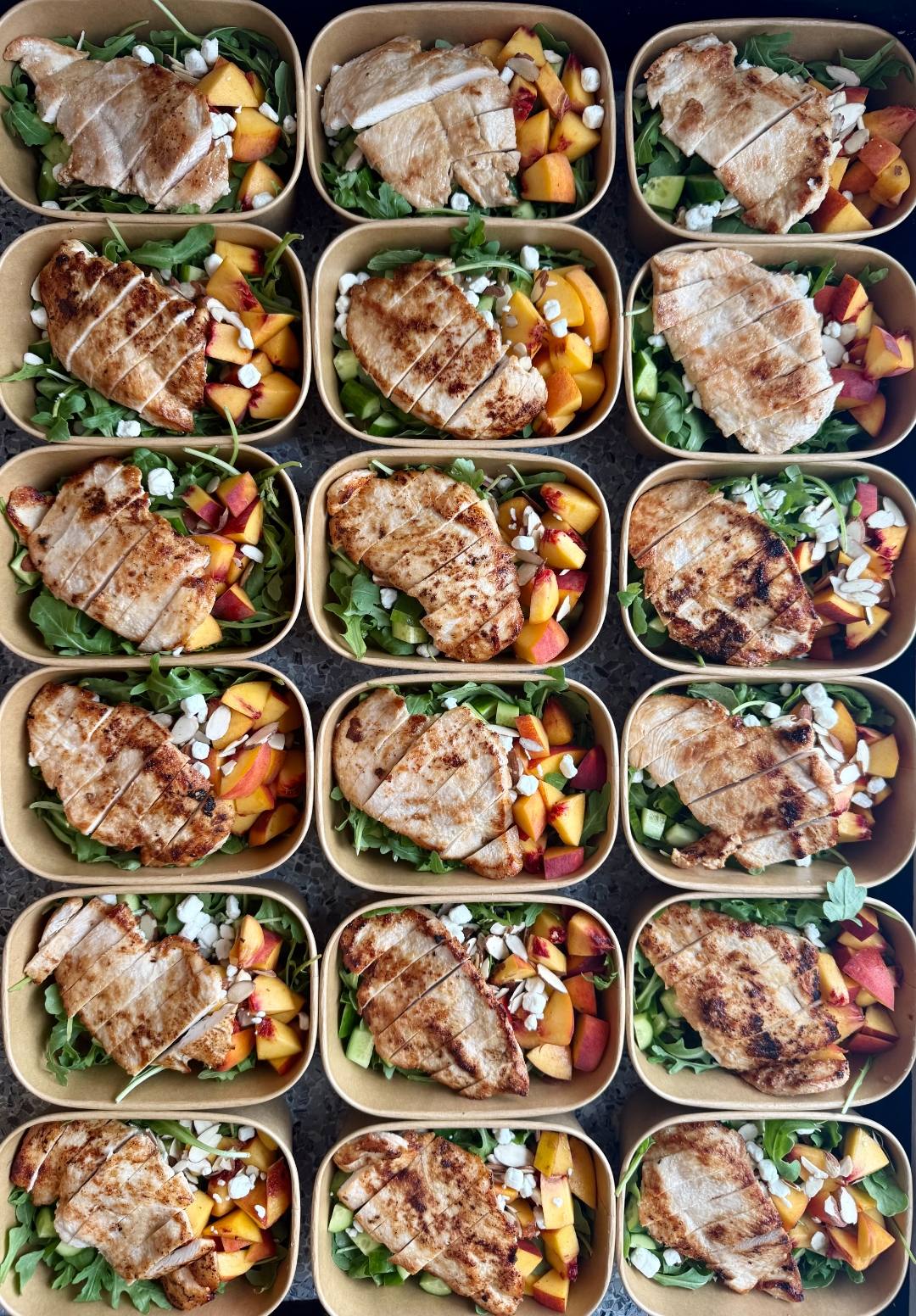 Grilled chicken salad meal prep with arugula, peaches, goat cheese, and almonds